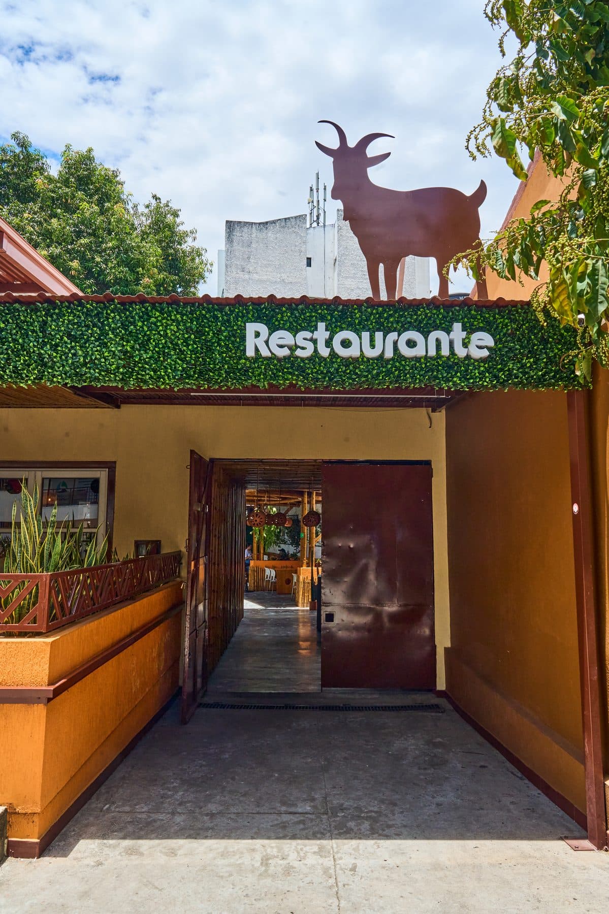 Entrada del restaurante Tatacoa con letrero y silueta de cabra
