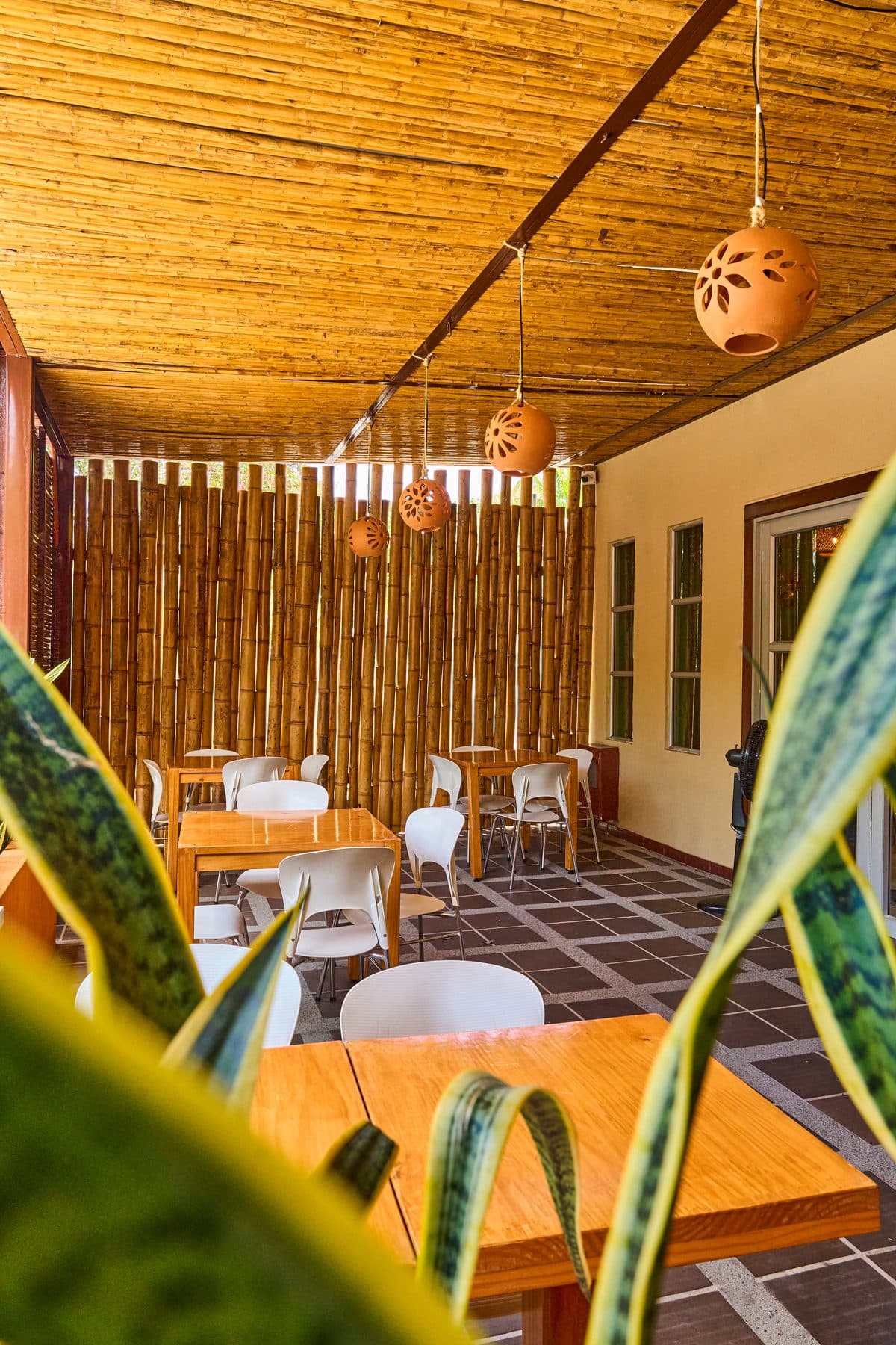 Terraza Tatacoa con mesas y vegetación en primer plano